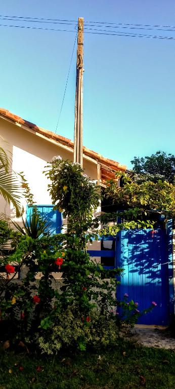 a house with a blue door with plants on it at Casinha do Bem-Viver na Vila de Itaúnas in Itaúnas