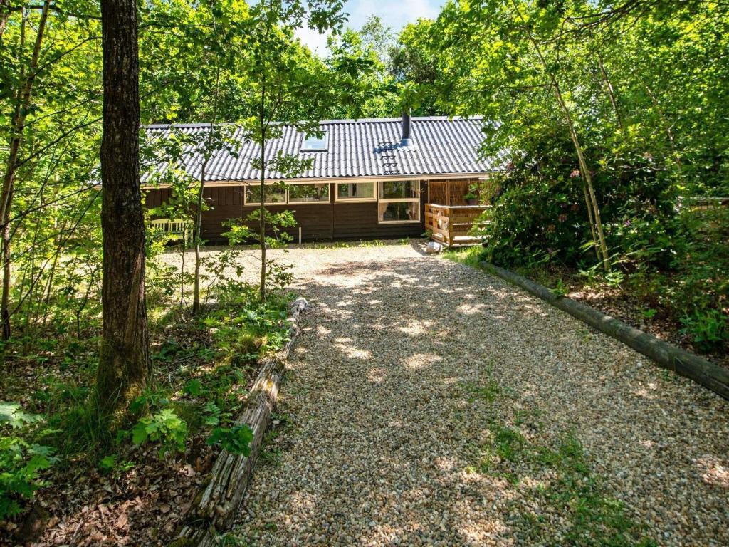a cabin in the woods with a gravel driveway at 5 person holiday home in Ansager in Ansager