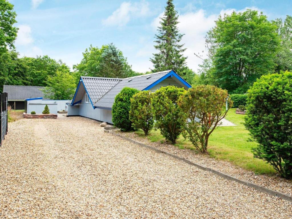 a blue house with a gravel driveway at 6 person holiday home in Ansager in Ansager