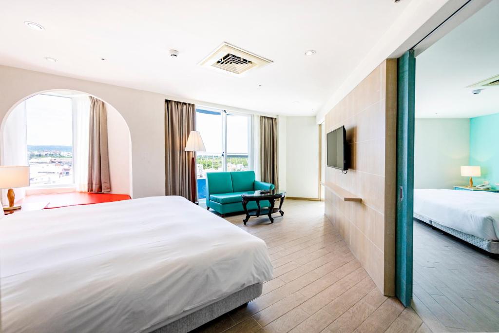 a large hotel room with a bed and a chair at Kenting Long Beach Hotel in Checheng