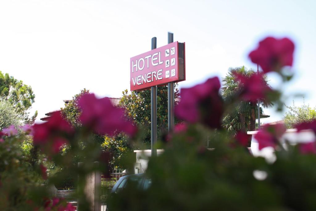 un panneau d'hôtel devant quelques fleurs dans l'établissement Hotel Venere, à Negrar