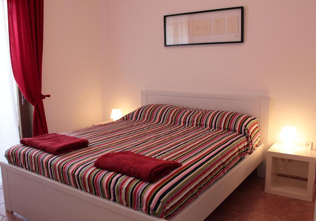 sypialnia z łóżkiem z 2 czerwonymi poduszkami w obiekcie Apartment "da Max" w mieście Palermo