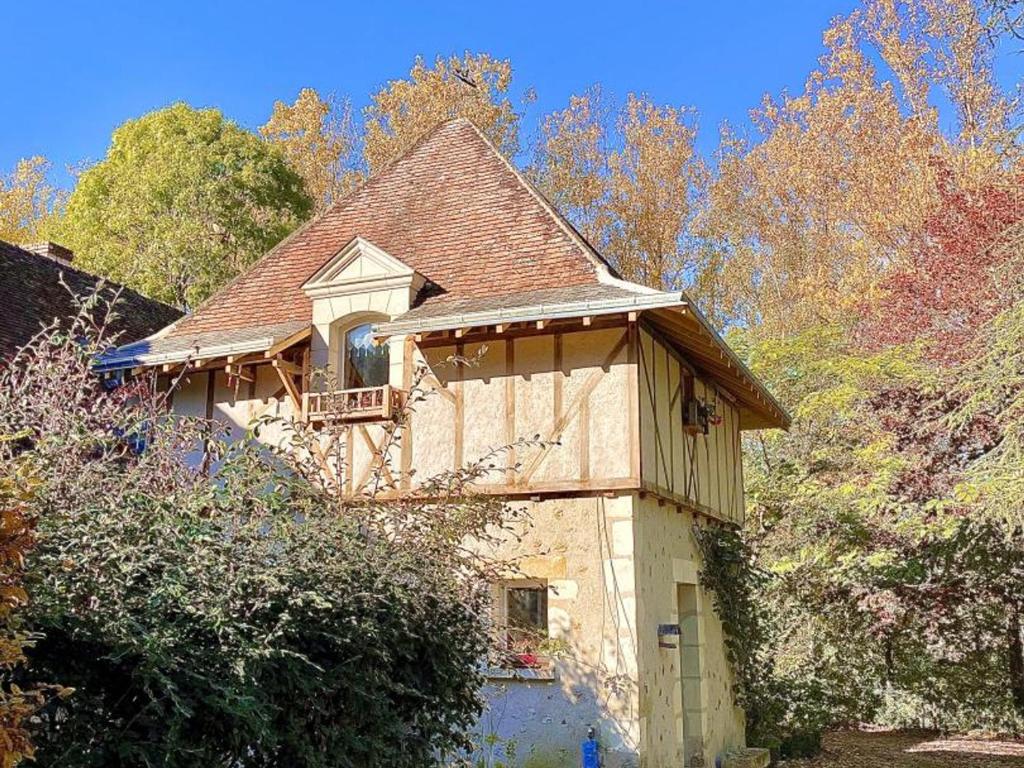 une maison avec un balcon sur le côté dans l'établissement Évasion Romantique: Charmant Gîte 2 Pers., Parc Boisé, Activités & Confort Tout Inclus - FR-1-381-455, à Souvigny-de-Touraine