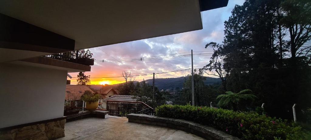 uma vista para o pôr-do-sol a partir de uma casa em Suítes Andorinhas em Monte Verde