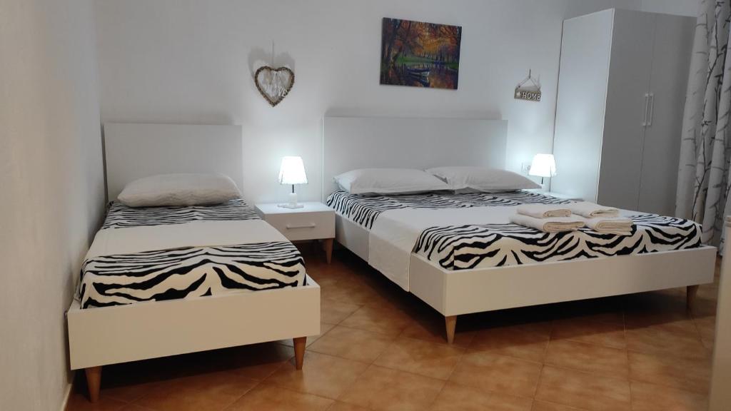 dwa łóżka w małym pokoju z dwoma lampami w obiekcie Marsel's House we Wlorze