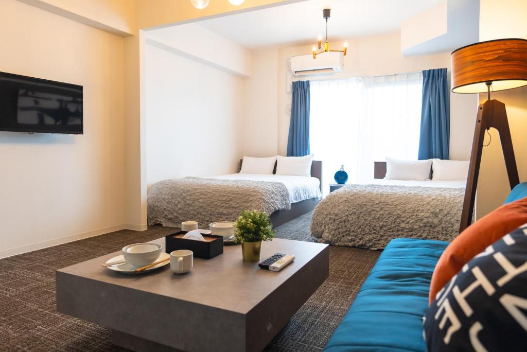 una habitación de hotel con dos camas y un sofá en 谷町君･星Hotel･恵美須西, en Osaka