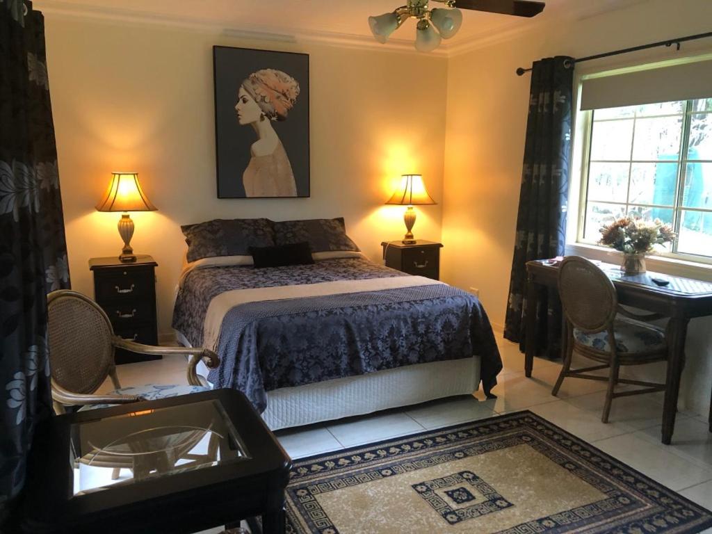 a bedroom with a bed and a desk and a window at Montrose in Apple Tree Creek