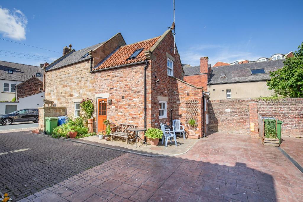 una casa de ladrillo con un patio delante de ella en Moor Croft, en Whitby