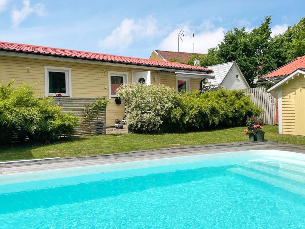 uma casa com piscina em frente a uma casa em Holiday home ÄNGELHOLM IV em Ängelholm