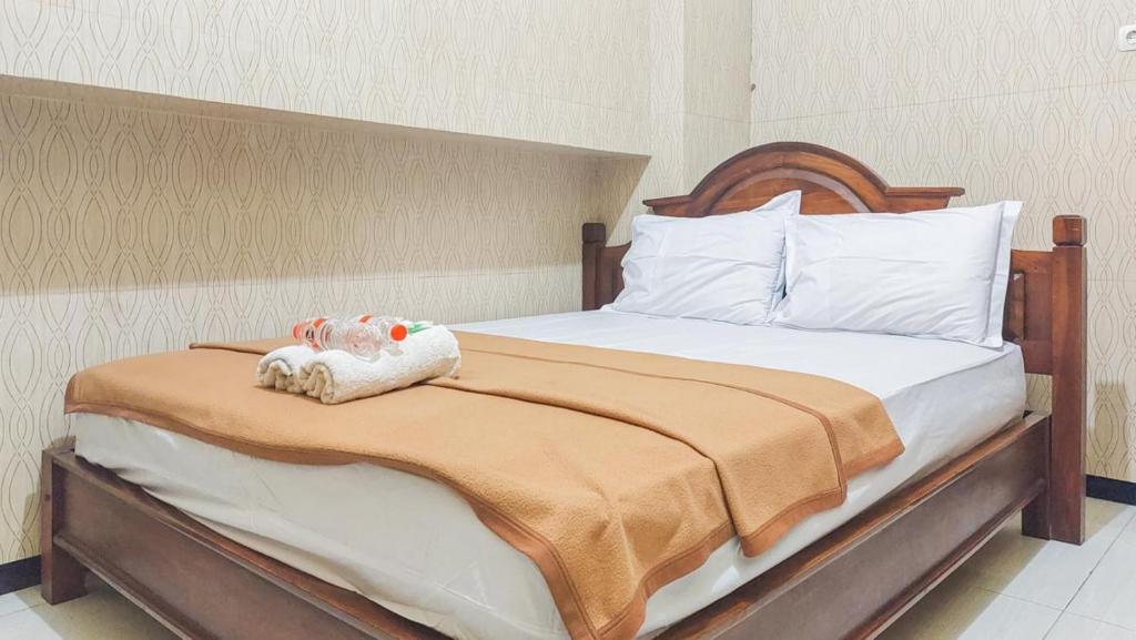 sypialnia z łóżkiem z wypchanym zwierzakiem w obiekcie Hotel Shinta 2 near Alun Alun Kertosono Mitra RedDoorz w mieście Pelem