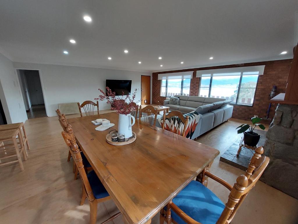 uma sala de estar com uma mesa de madeira e cadeiras em House Matterhon 3 Bedroom Apartment em Jindabyne