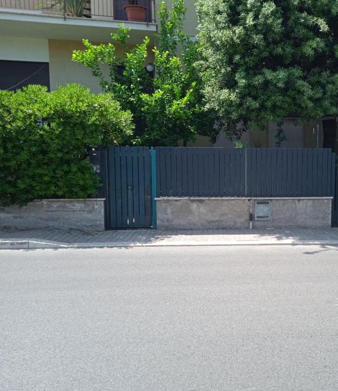 a fence with a blue gate in front of a building at Casa SoleMare a pochi passi dalla spiaggia di Terracina in Terracina