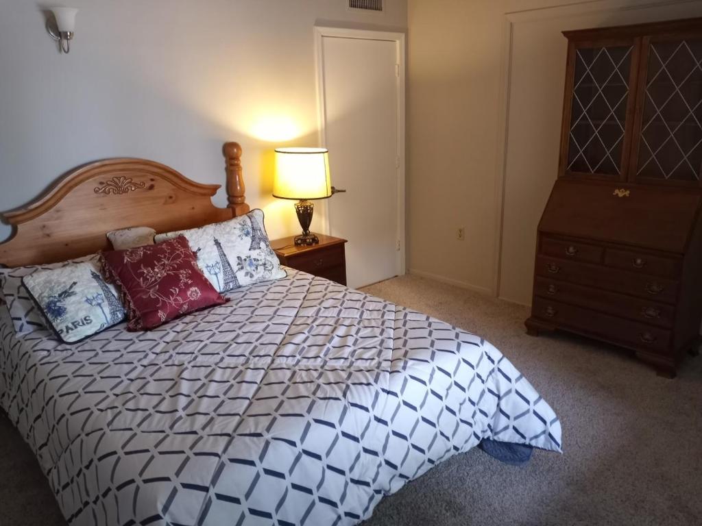 um quarto com uma cama com almofadas e um candeeiro em Dodge Residence em Tucson