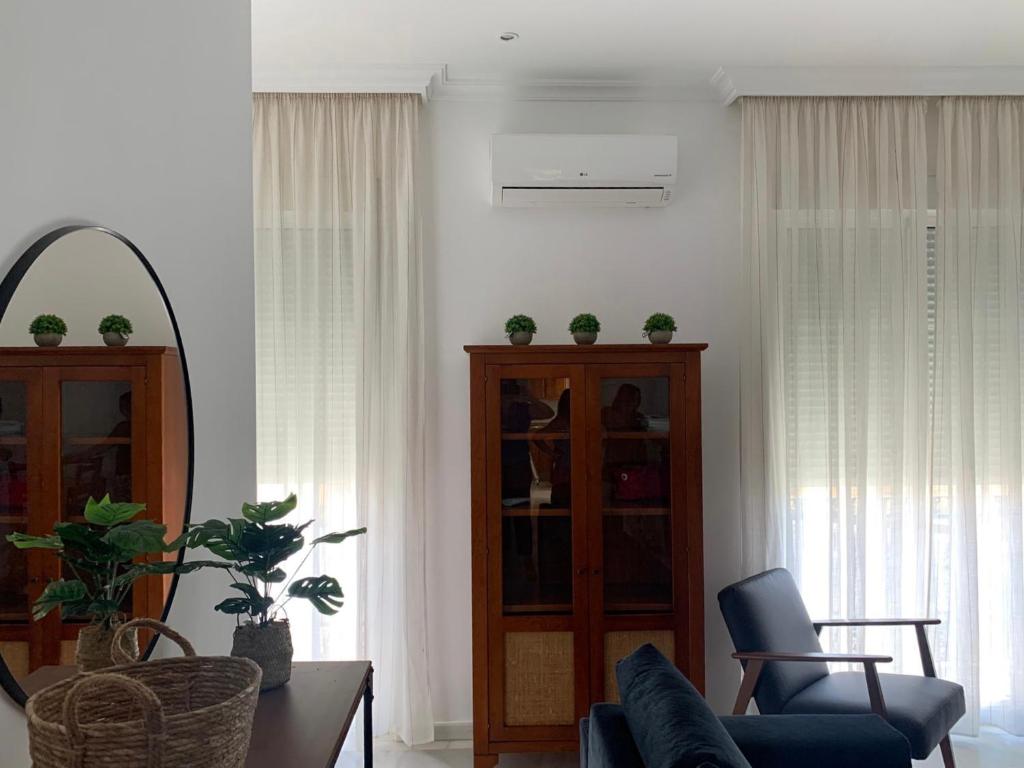 uma sala de estar com um sofá e uma cadeira em Apartamentos Casa Tuli C, ALJARAQUE em Aljaraque