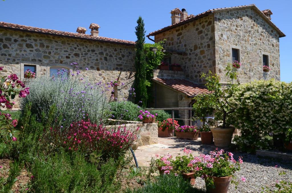una casa de piedra con flores delante en Country house Grencaia, en Chianciano Terme
