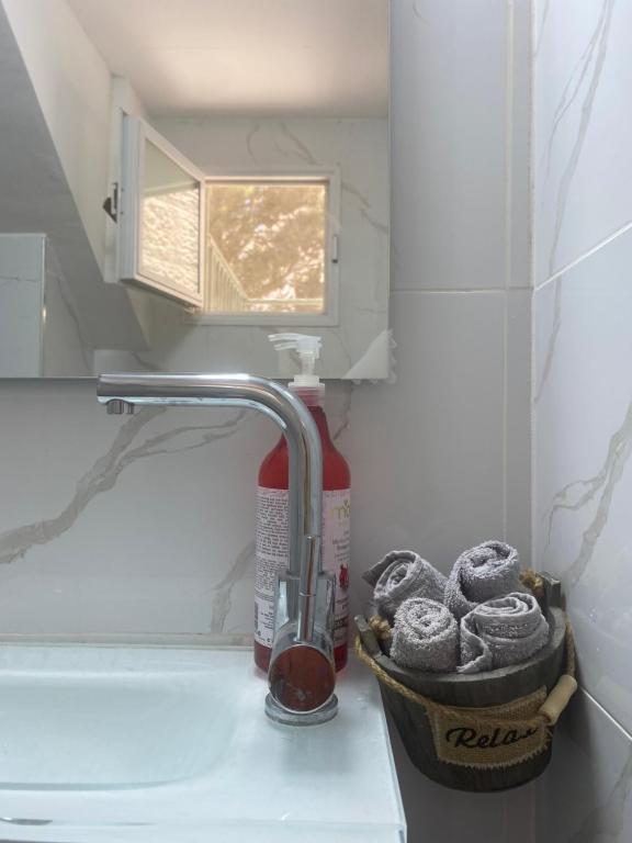 a bathroom sink with a faucet and a basket of cookies at דירת גן מרווחת במיקום מעולה עם נטפליקס חינמי in Ma'ale Adumim