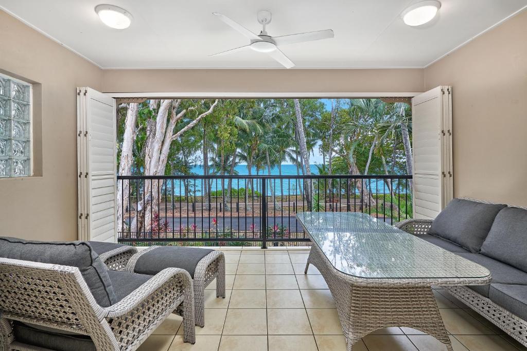 a living room with a couch and a table and chairs at Coral Views at Clifton Beach in Clifton Beach