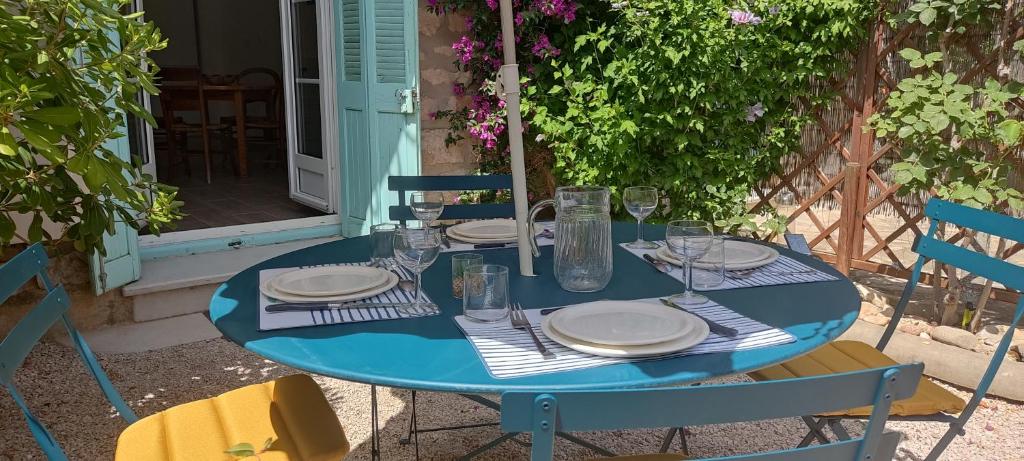 een blauwe tafel met borden en glazen erop bij Le Gabian, duplex proche plage et centre in Sanary-sur-Mer