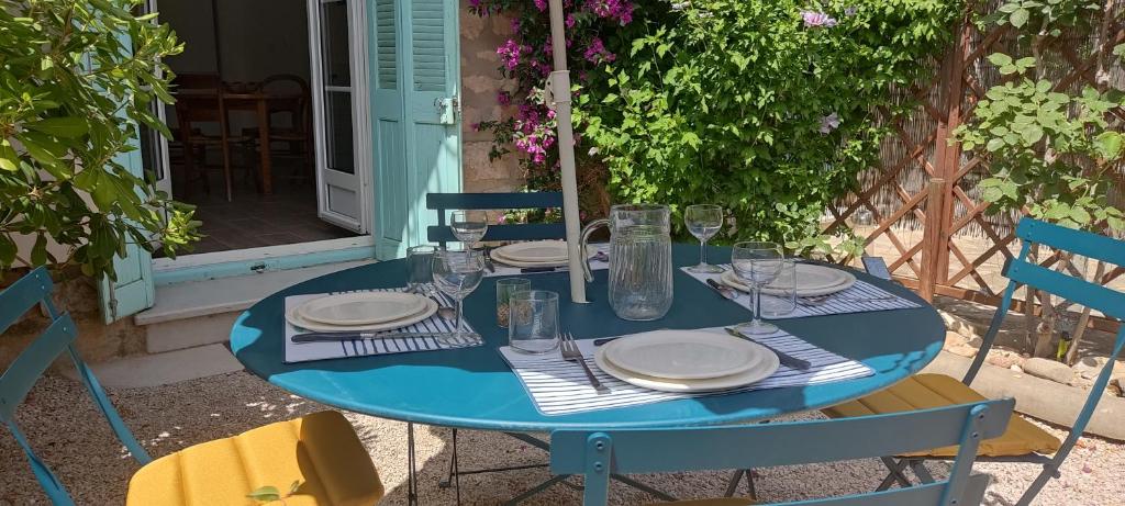 une table bleue avec des assiettes et des verres dans l'établissement Le Gabian, duplex proche plage et centre, à Sanary-sur-Mer