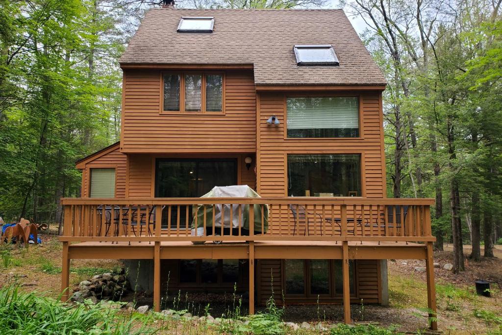 a large house with a deck in the woods at Woodland Gateway in Conway
