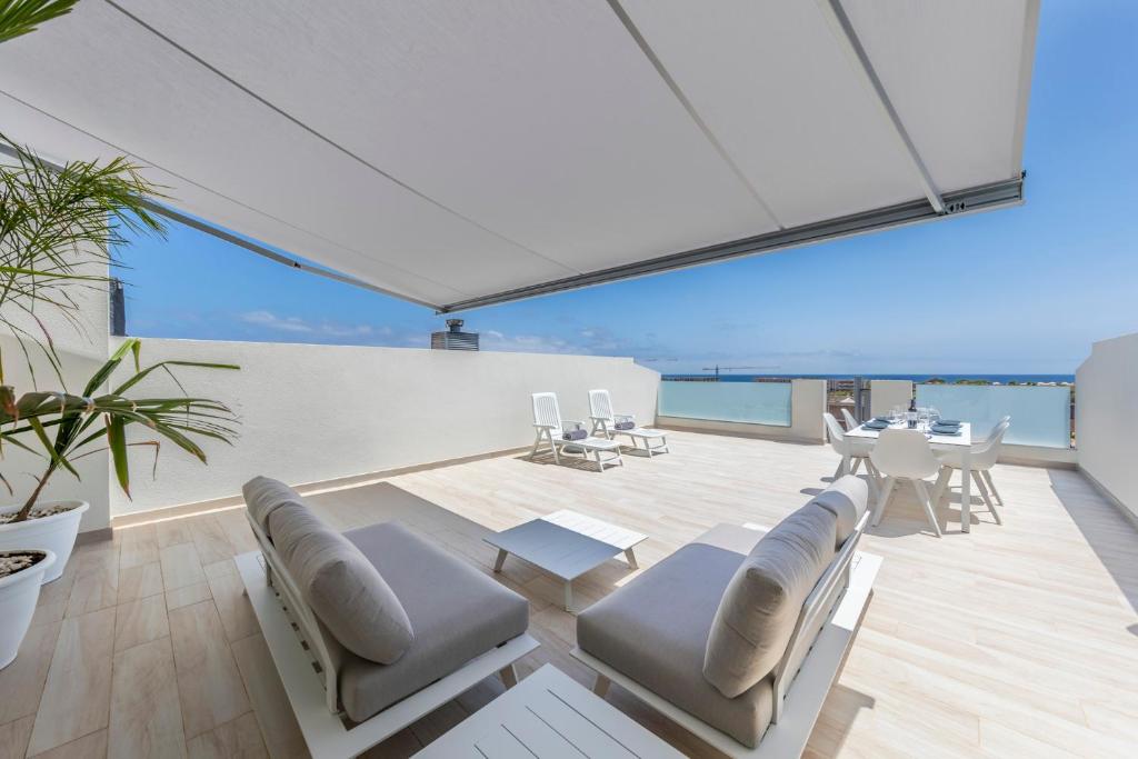 a living room with white furniture and a view of the ocean at MEDANO4YOU Carpe Diem La Tejita in La Tejita