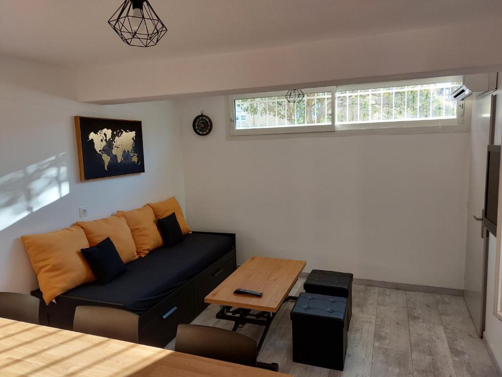 ein Wohnzimmer mit einem Sofa und einem Tisch in der Unterkunft appartement T2 AGDE centre à 10 mn des plages in Agde
