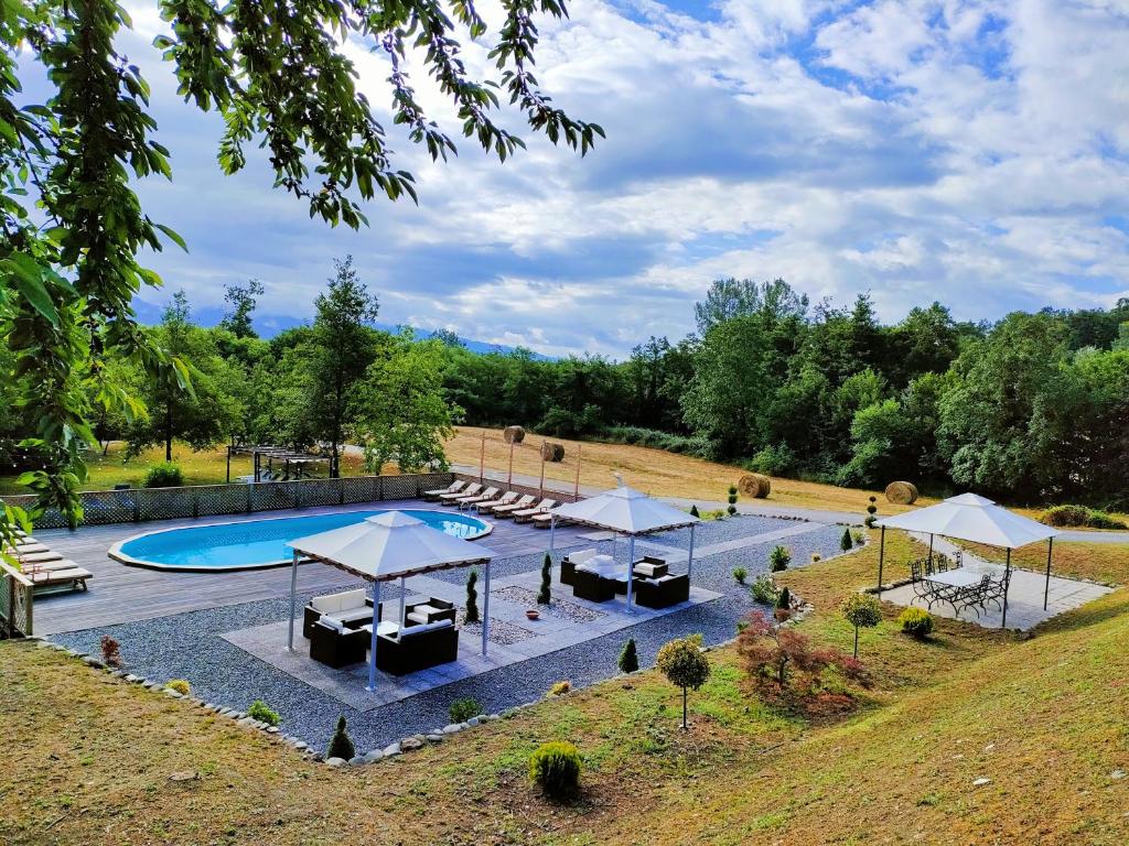 Agriturismo Borgo Biaia في Camporgiano: وجود مسبح بالطاولات والمظلات في الحديقة