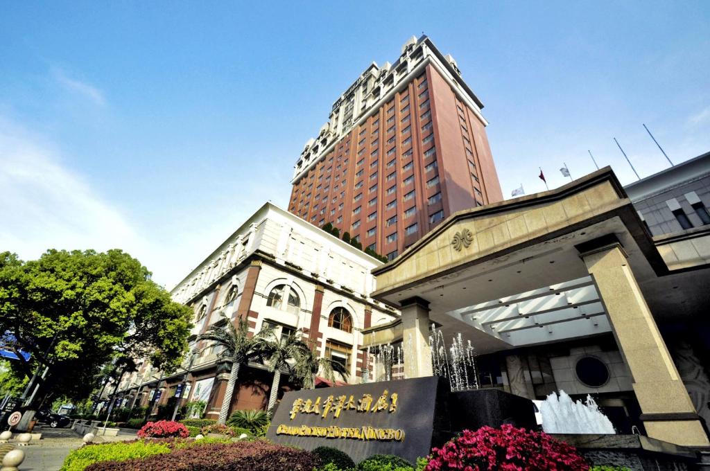 a building with a sign in front of it at Grand Pacific Hotel Ningbo in Yuyao