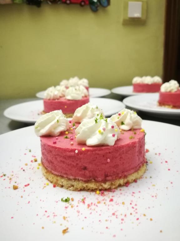 a pink cake with white frosting and sprinkles on a table at Le Clos des Chênes in Lagarde-Paréol