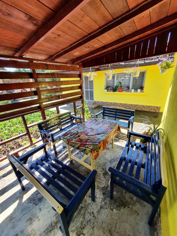 a patio with three blue benches and a table at Casa de vacanță Anni - 2 min de piață in Eforie Nord