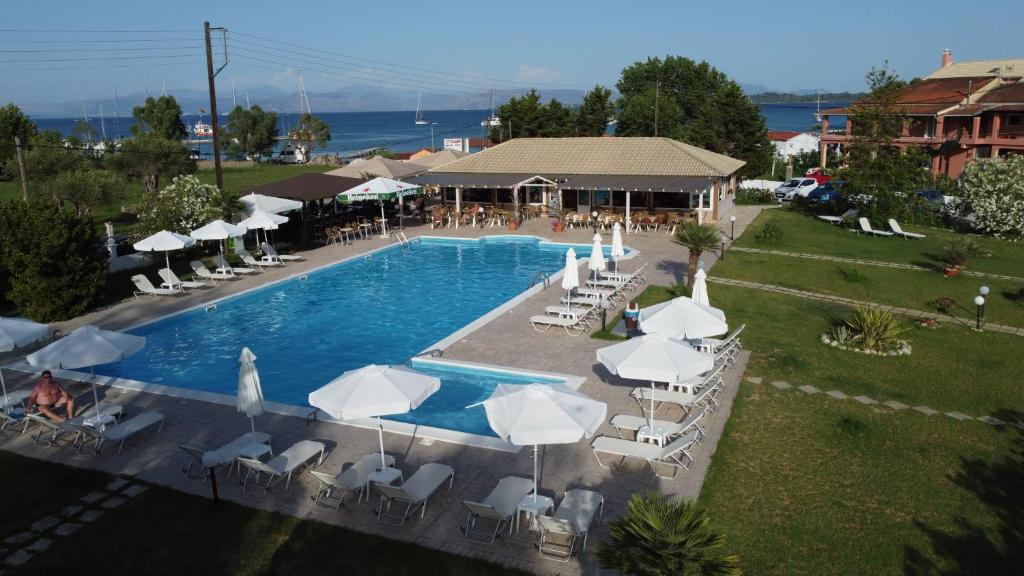 an overhead view of a swimming pool with chairs and umbrellas at Egrypos Hotel in Petrití