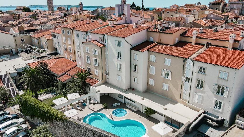 an aerial view of a building with a swimming pool at Hotel International in Rab