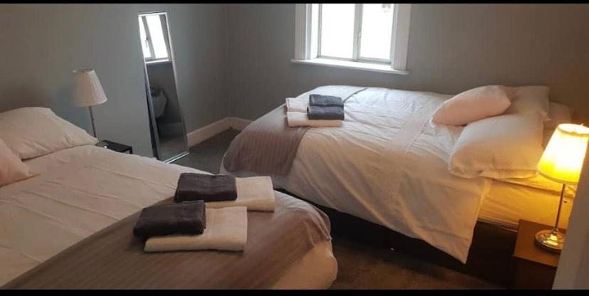 2 Betten in einem Schlafzimmer mit Handtüchern darauf in der Unterkunft Recently Renovated House in Heart of Galway City in Galway