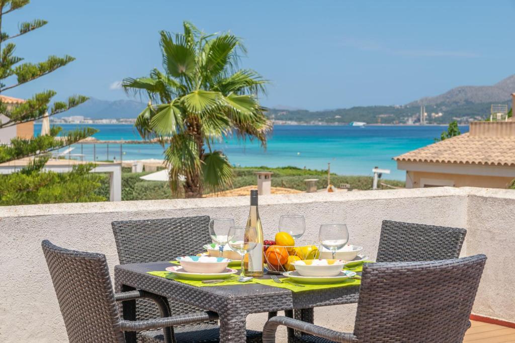 a table with a bottle of wine and fruit on a balcony at Violeta de Mar in Playa de Muro