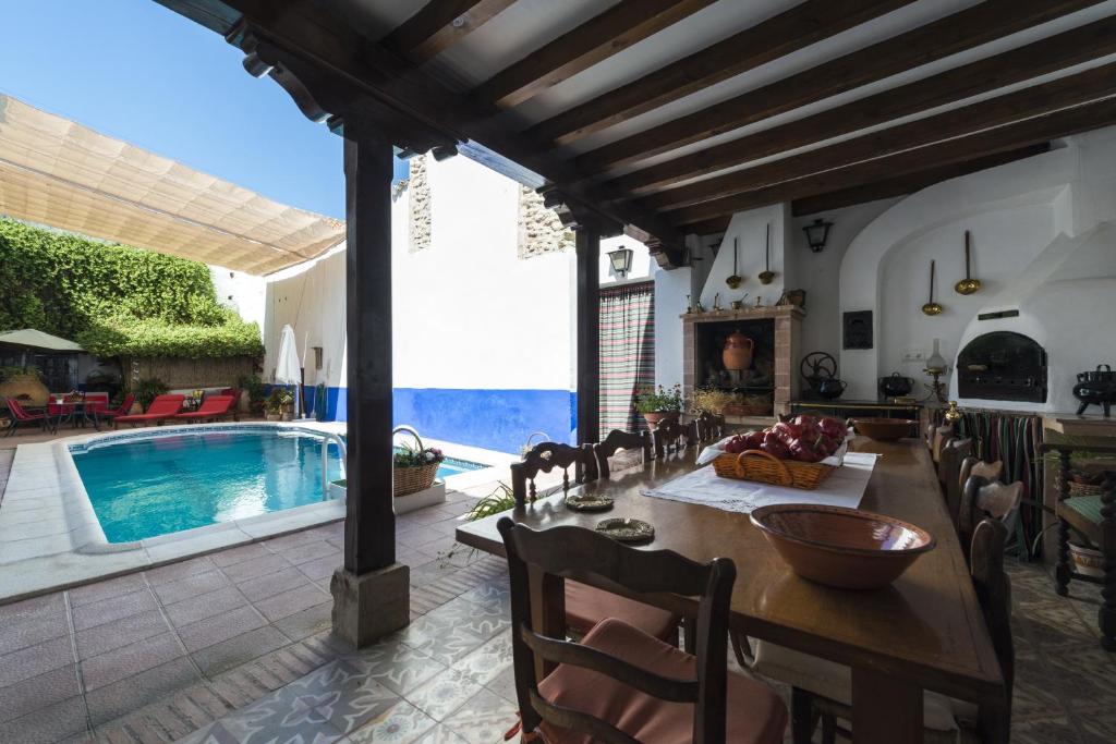 a dining room with a table and a swimming pool at Hotel Rural Tia Pilar in Almagro