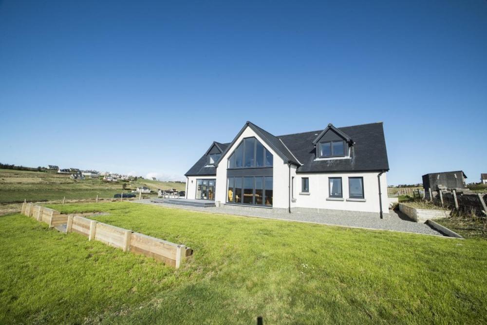 une grande maison blanche avec une grande pelouse dans l'établissement Clach Gorm, à Stornoway
