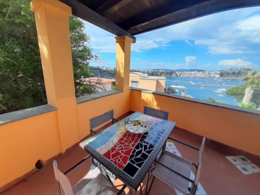 uma mesa e cadeiras numa varanda com vista para a água em Casa Raia - Overlooking the sea em Procida