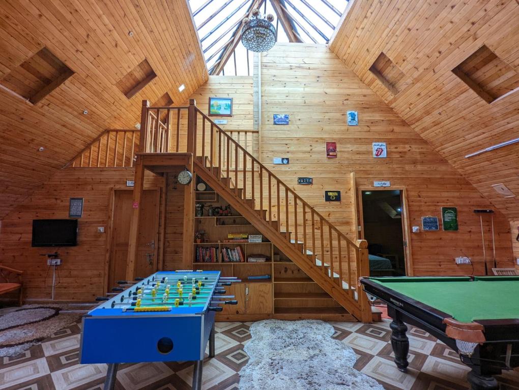 a room with a pool table and a staircase at The Door to Nirvana Backpackers Hostel Kotagiri in Kotagiri