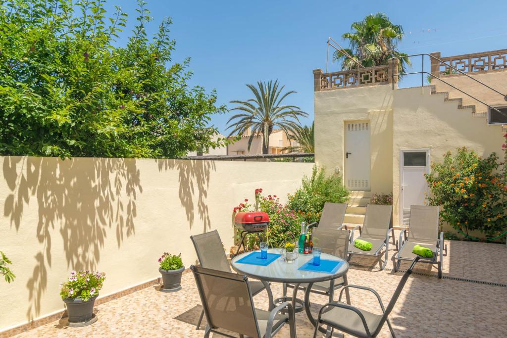 a patio with a table and chairs in front of a building at Vila Ca Shermano in Colonia de Sant Pere