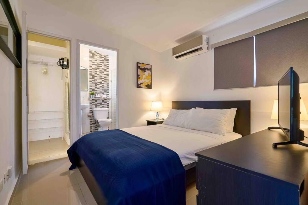 ein Schlafzimmer mit einem Bett und einem Schreibtisch. in der Unterkunft Escape Studio Apartment Close to Agora Mall in Santo Domingo