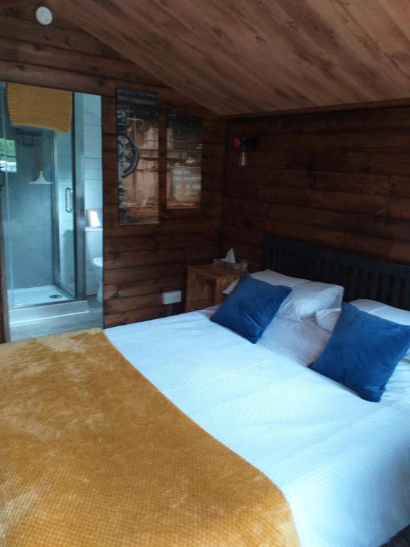 1 dormitorio con 2 camas y almohadas azules en Delightful cosy cabin, en Margate