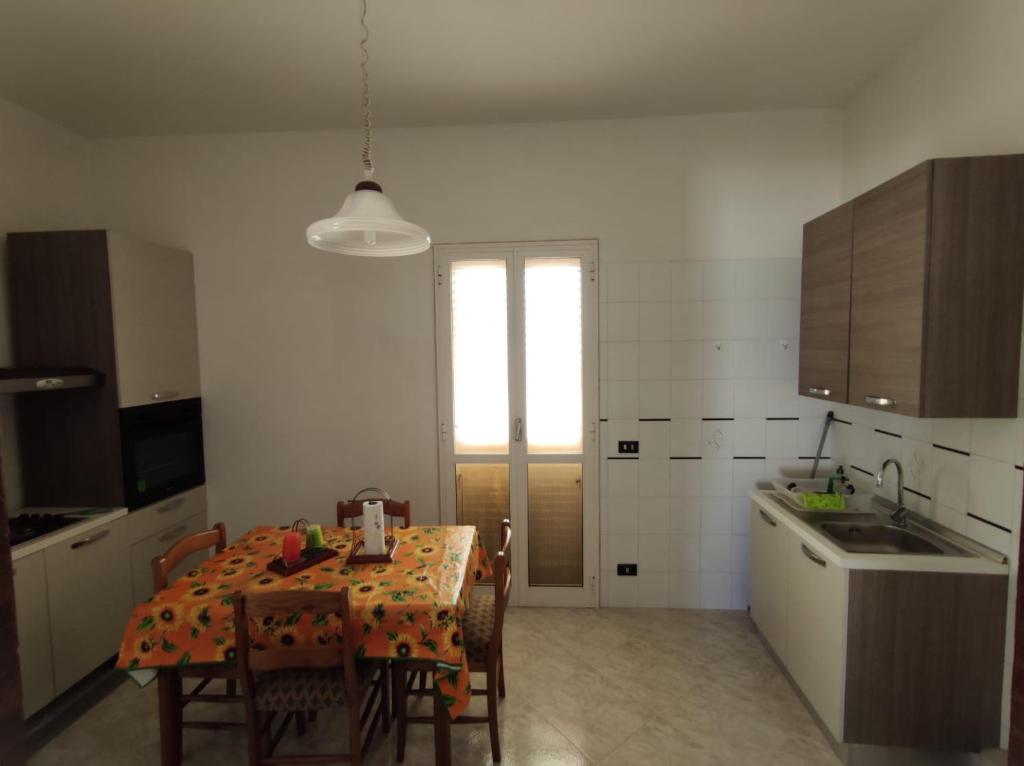 ファザーノにあるLa casa di Nonnoのキッチン(テーブル、椅子付)、窓付きのキッチン