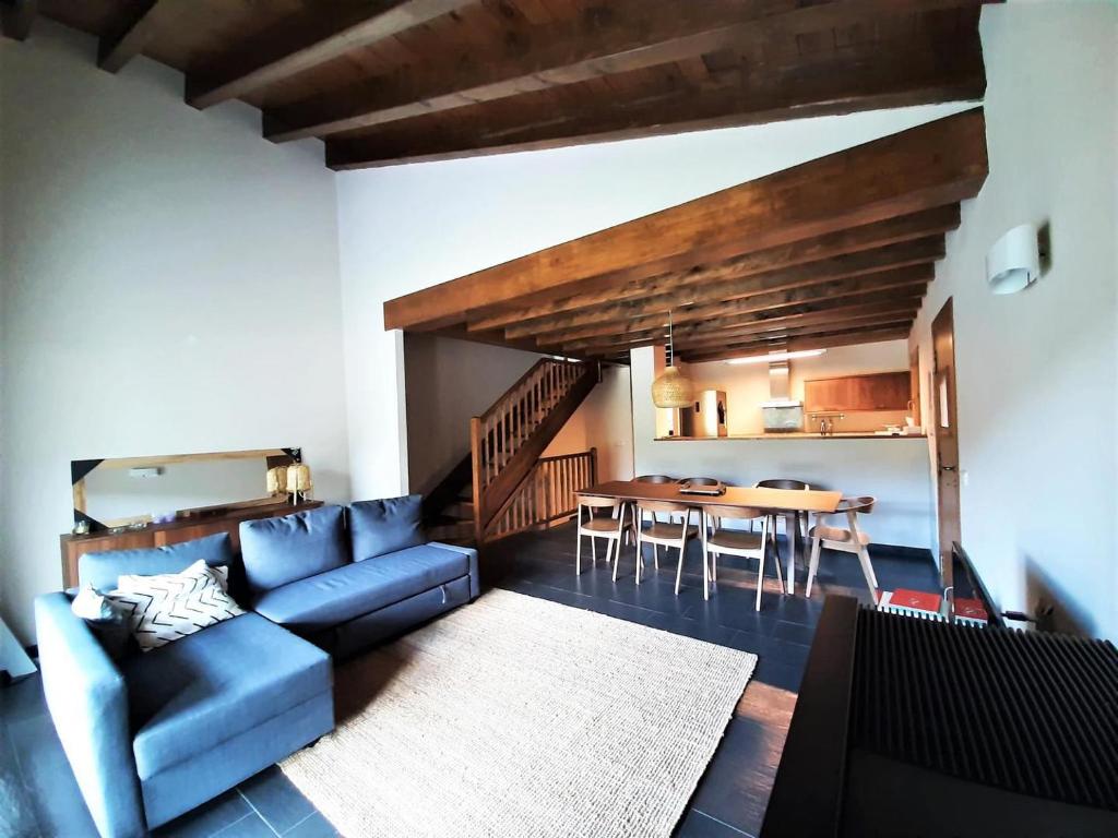 sala de estar con sofá azul y mesa en Casa con impresionantes vistas en Martinet, en Martinet