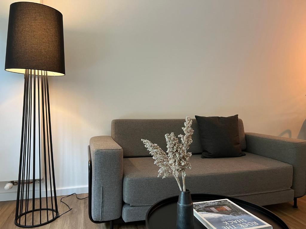sala de estar con sofá y mesa con lámpara en Apartmenthaus Stade Schwingewiesen Apartment 1, en Stade