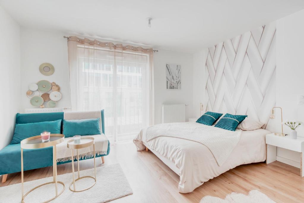 biała sypialnia z łóżkiem i kanapą w obiekcie L'élégant portes de Paris- Parking-5'RER B w mieście Gentilly