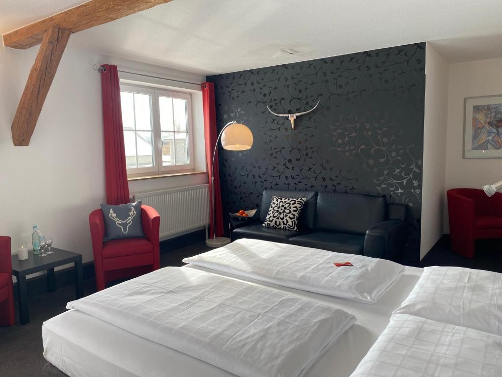 une chambre d'hôtel avec un lit et un canapé dans l'établissement Landhotel Zerlaut, à Kißlegg