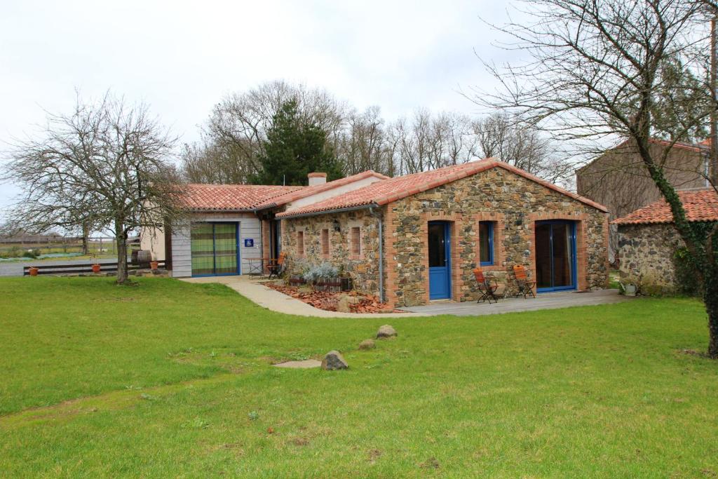 kamienny dom na podwórku z zielonym trawnikiem w obiekcie Maison de 3 chambres avec jardin clos et wifi a Mouzillon w mieście Mouzillon