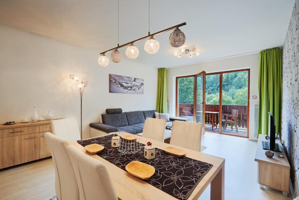 een eetkamer en een woonkamer met een tafel en stoelen bij Apartment Bonita Tále in Bystrá