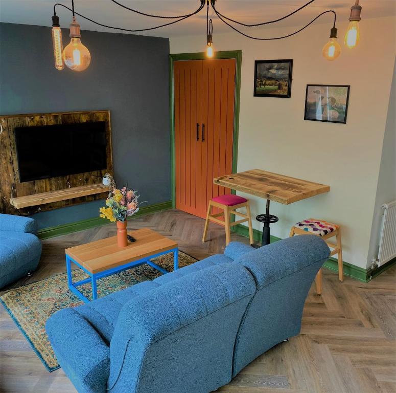 - un salon avec un canapé bleu et une table dans l'établissement The Bolthole @ Bowness - Cosy 1 Bed Apartment, à Bowness-on-Windermere