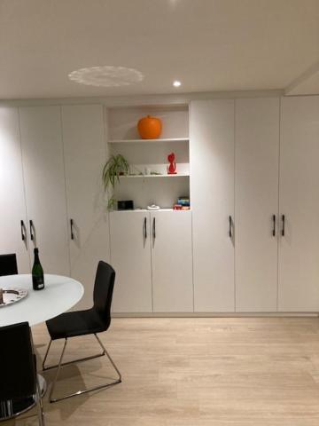 ニーウポールトにあるChristinaの白いキャビネットとテーブルと椅子のある部屋